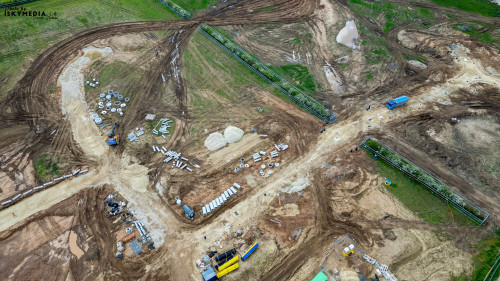 Aerial view of a construction site with various materials and machinery in a rural setting at Bellway Homes in Boroughbridge, UK.