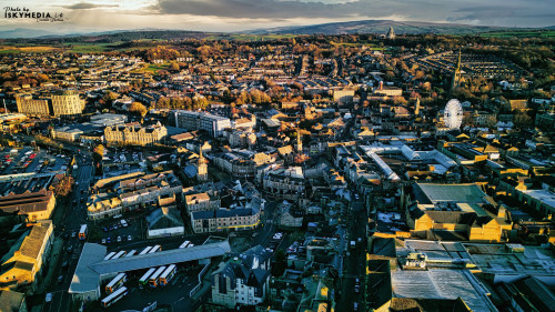Aerial view of a city Lancaster at sunset with warm lighting highlighting the buildings and streets, showcasing the urban landscape.